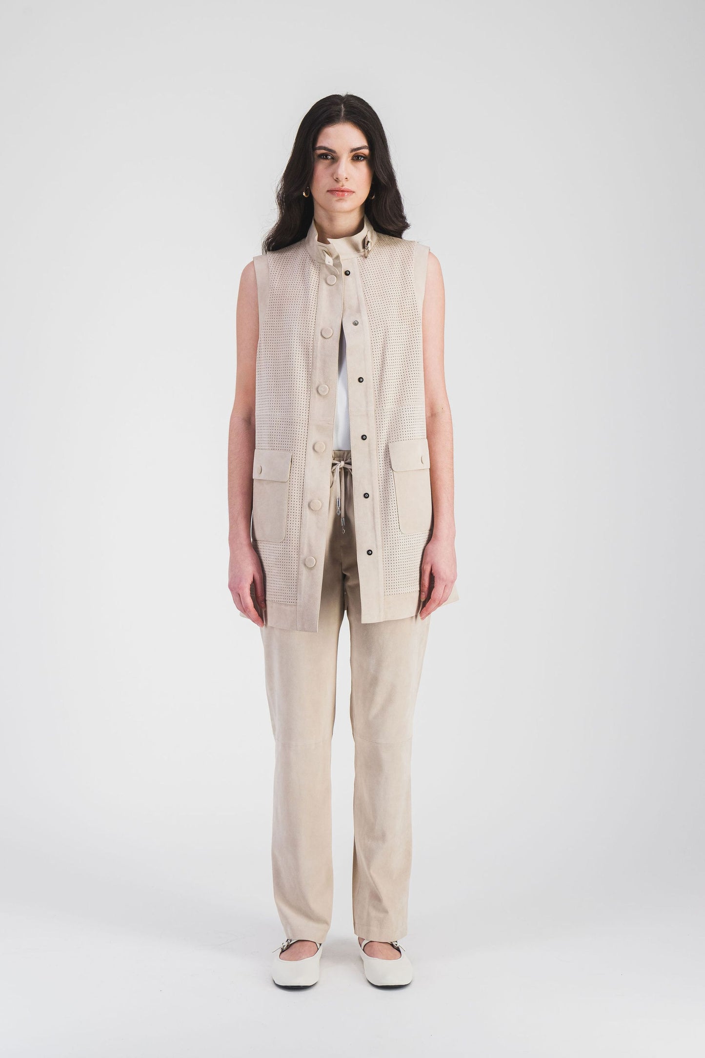 Veste moderne en daim beige clair, avec col camionneur et poches plaquées, offrant confort et une coupe mi-longue élégante.