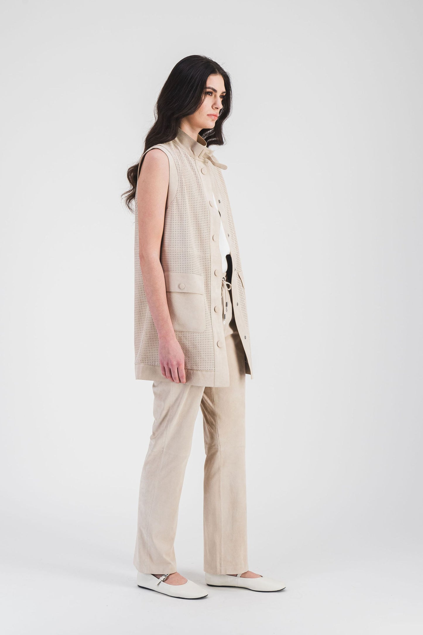 Veste perforée en daim beige clair, avec col camionneur et grandes poches, pour un look à la fois moderne et fonctionnel.