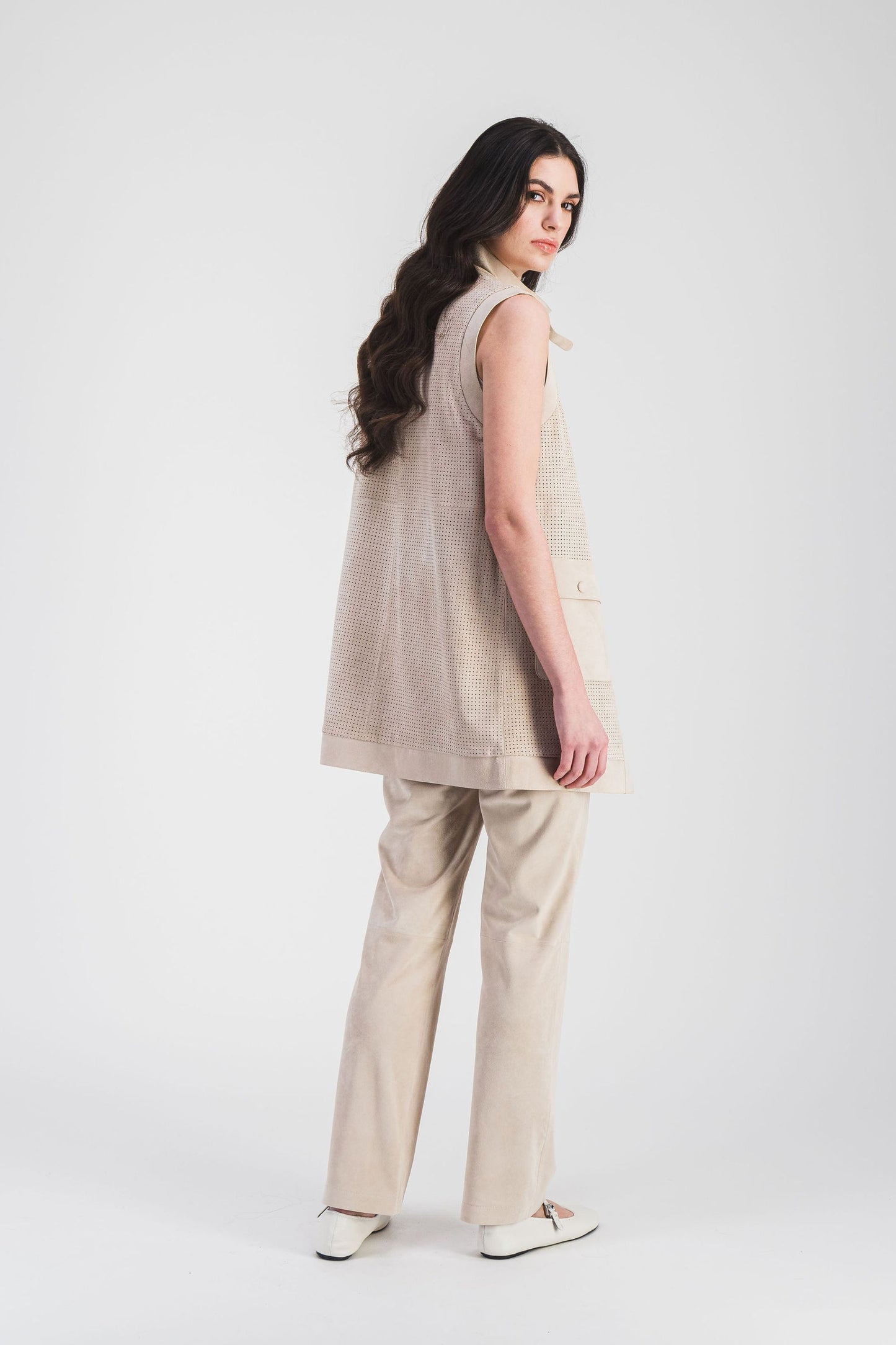 Veste en daim beige clair à perforations audacieuses, avec col camionneur et poches plaquées, idéale pour un look moderne.