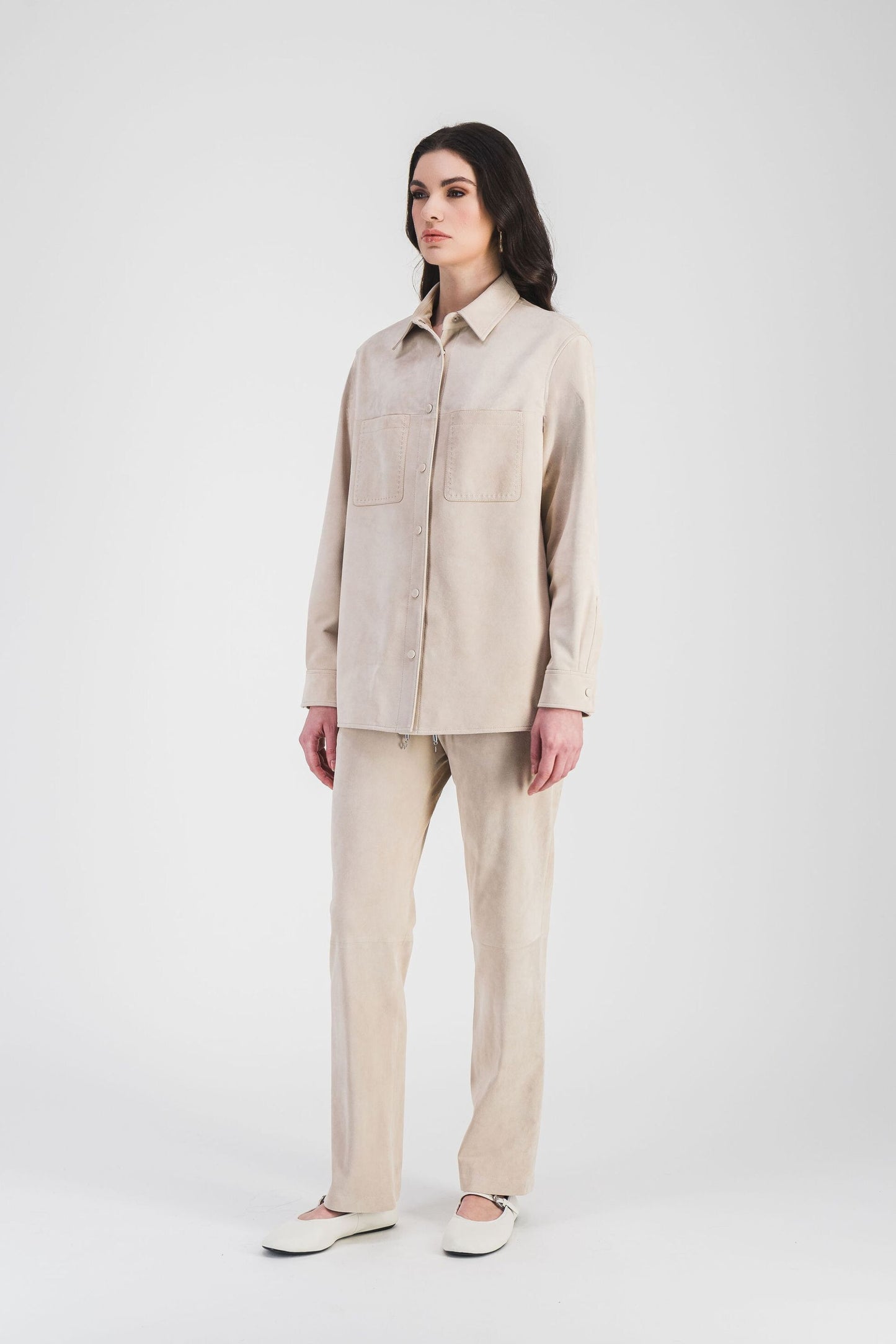 Cette surchemise beige clair en daim souple avec poches et surpiqûres raffinées est idéale pour une silhouette moderne et chic.