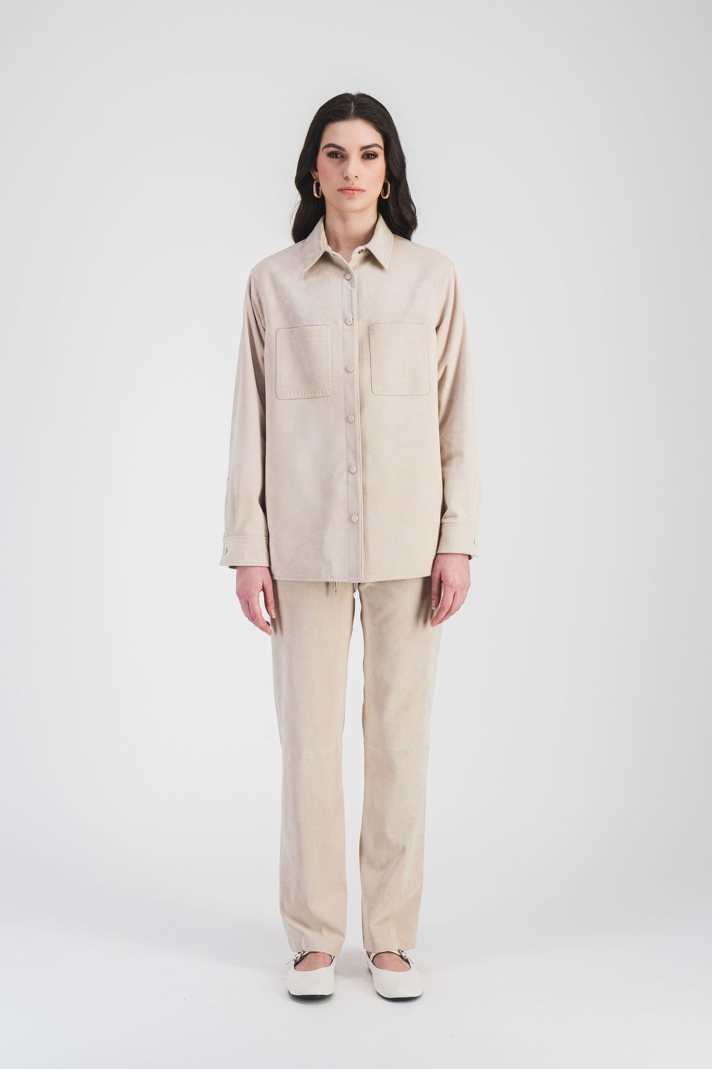 Surchemise beige clair en daim souple avec poches et boutons recouverts de daim, pour un look chic et pratique au quotidien.