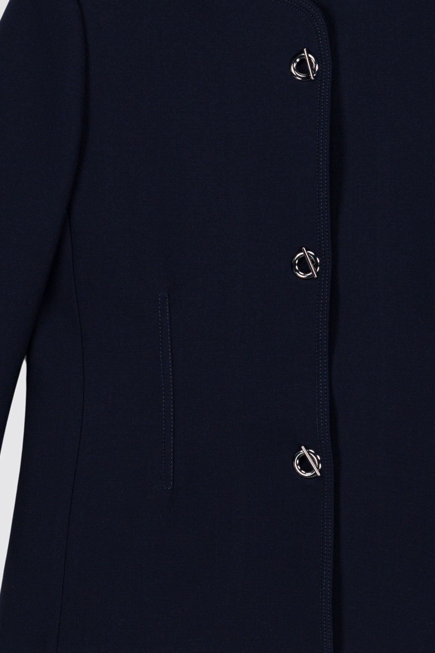 Cette veste bleu marine à manches 3/4, dotée de boutons œillet métallisés.