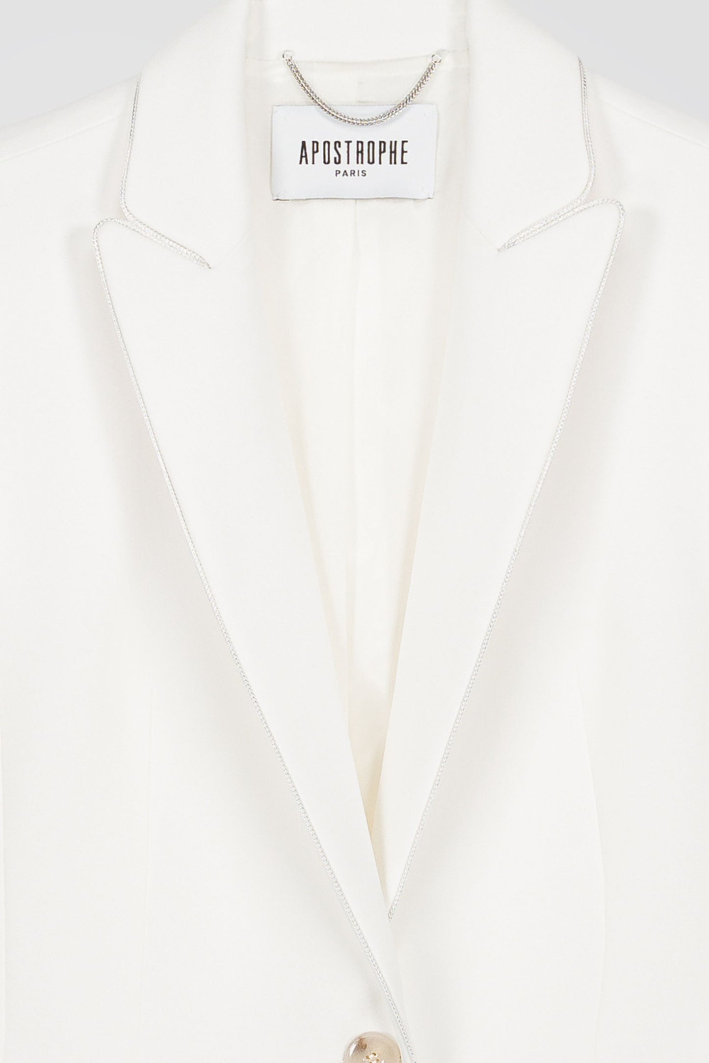 Une veste ajustée blanche cassée avec une coupe élégante, des poches à rabat et des détails raffinés.