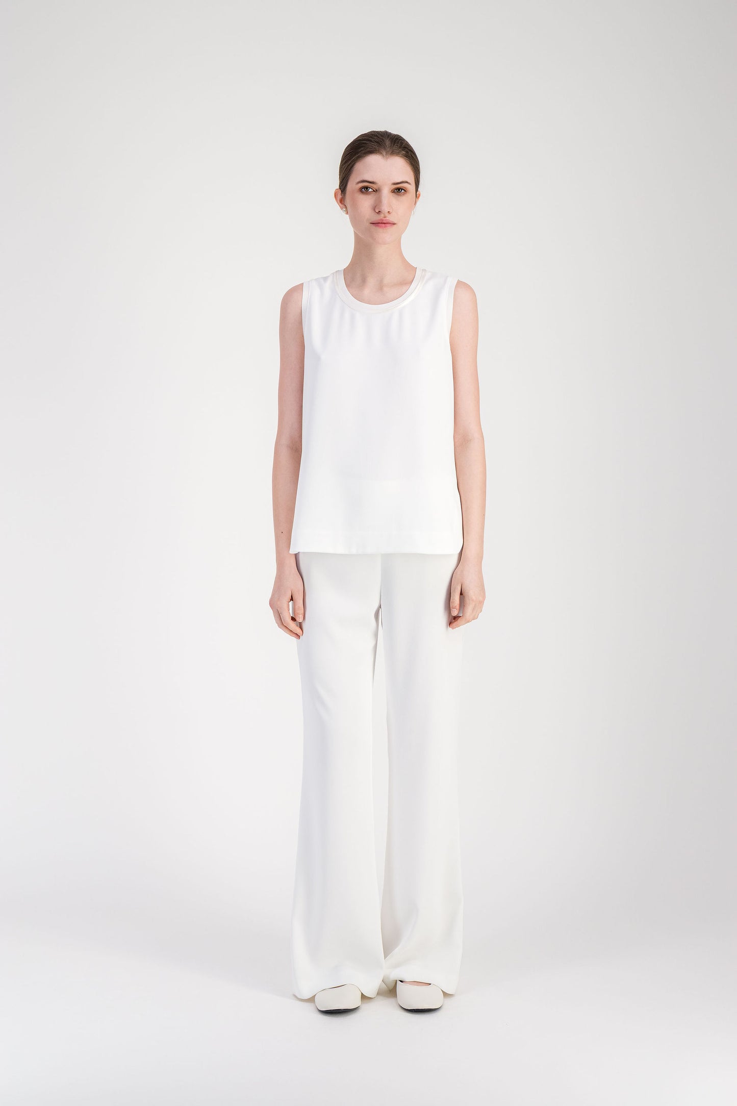 Top ample blanc cassé sans manches avec col rond et détail satiné.