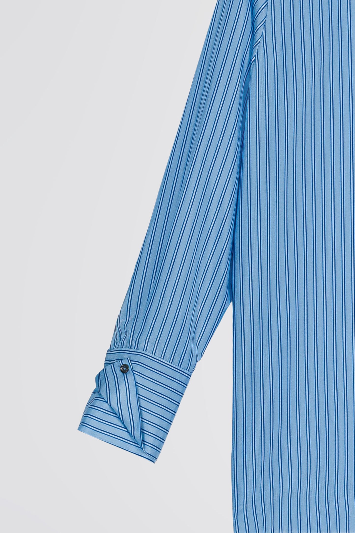 Chemise droite en soie habotai bleu denim avec motif rayé, poignets doubles et boutons gravés pour un look sophistiqué et élégant.