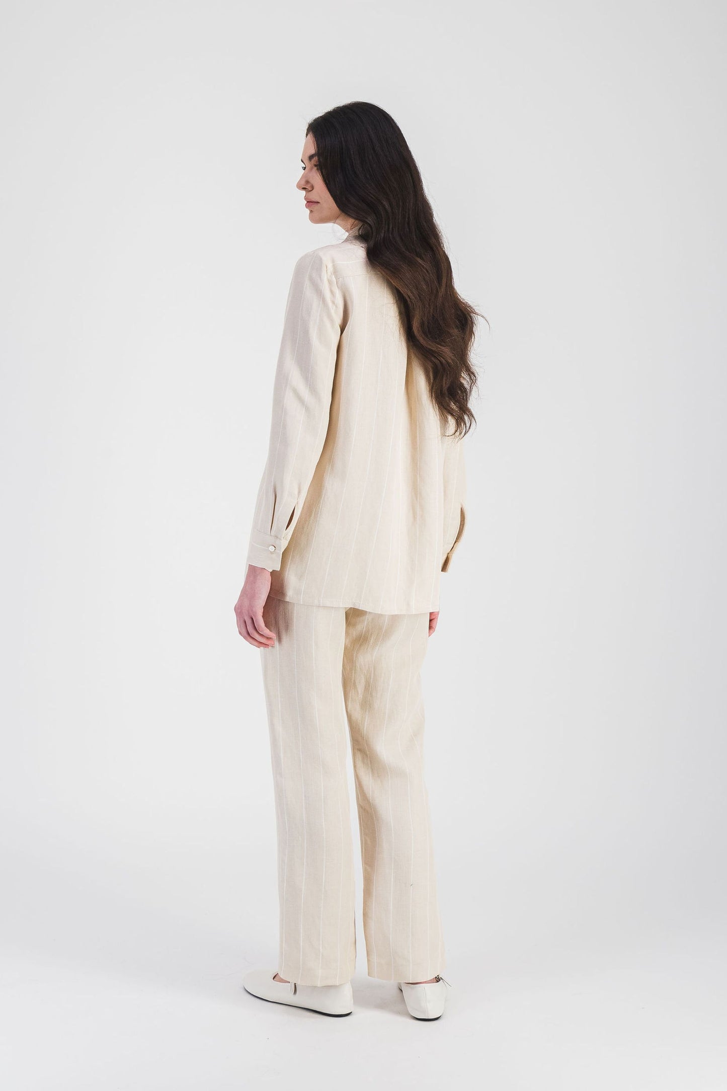 Confectionnée en lin beige, cette chemise à rayures fines apporte confort et style, parfaite pour un look décontracté chic.