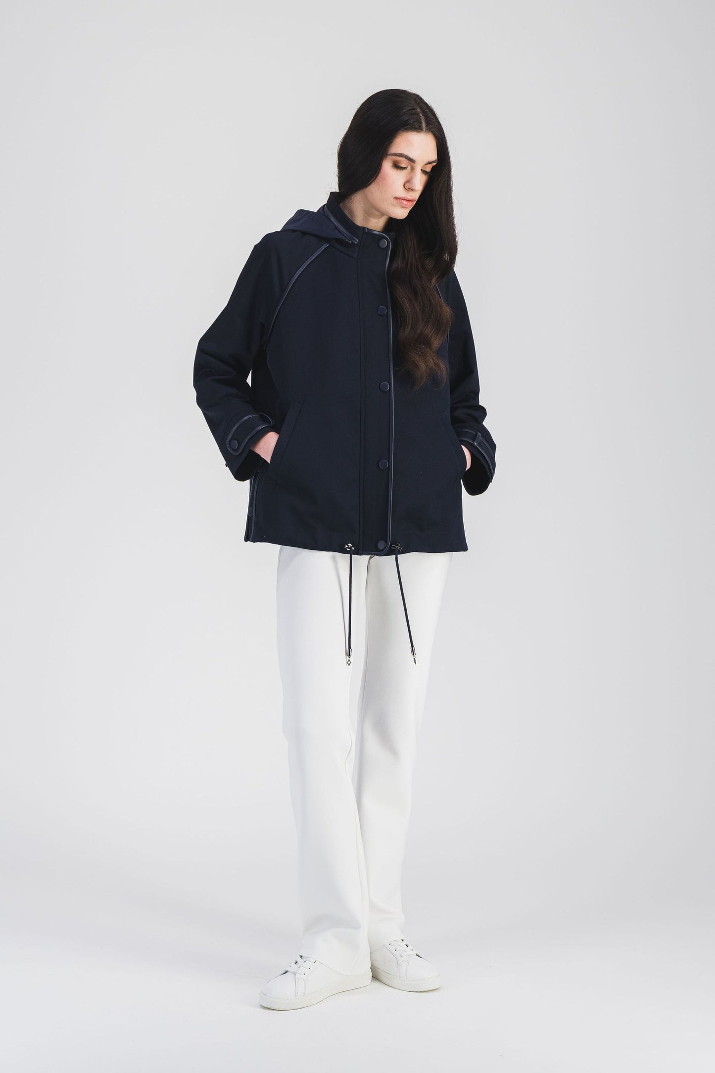 Trench court en coton marine, signé Apostrophe, avec capuche contrastante et embouts métalliques logotés.