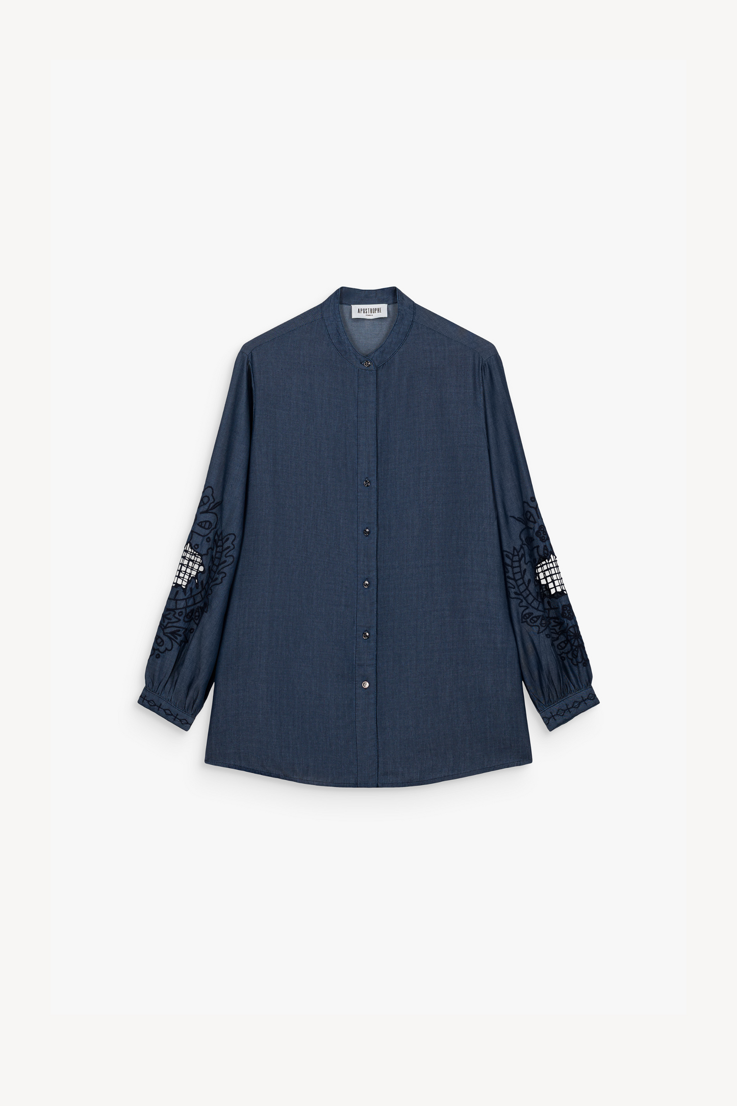 Blouse en chambray bleu délavé, souple et résistante, avec col mao contemporain. Broderies délicates aux manches et patte de boutonnage cachée.