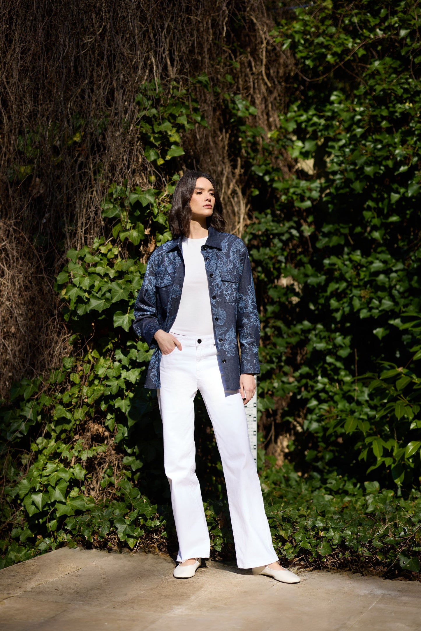 Chemise féminine en denim à fleurs marines, poche plaquée et finitions raffinées.