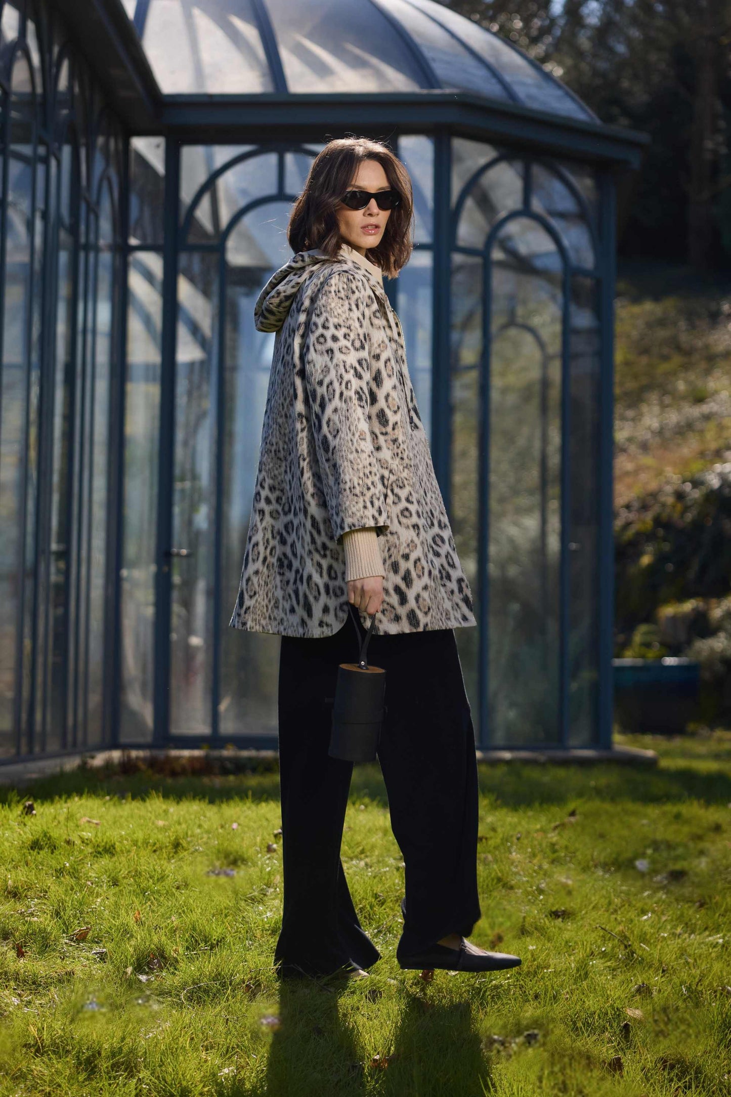 Parka ébène chic à capuche avec fermeture bijou, fentes côtés et finitions élégantes.