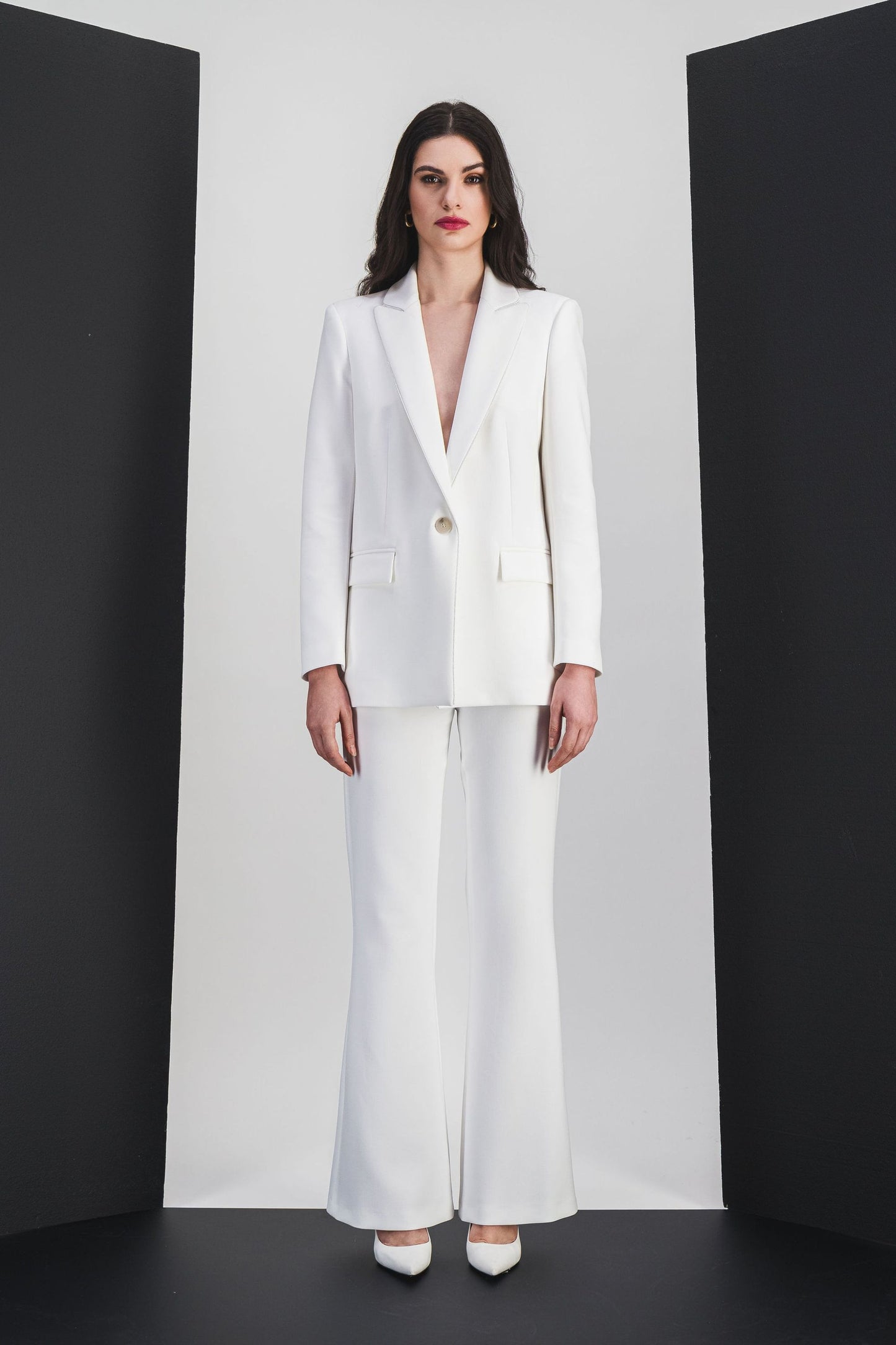 Cette veste ajustée en blanc cassé, avec ses finitions soignées et son simple boutonnage.