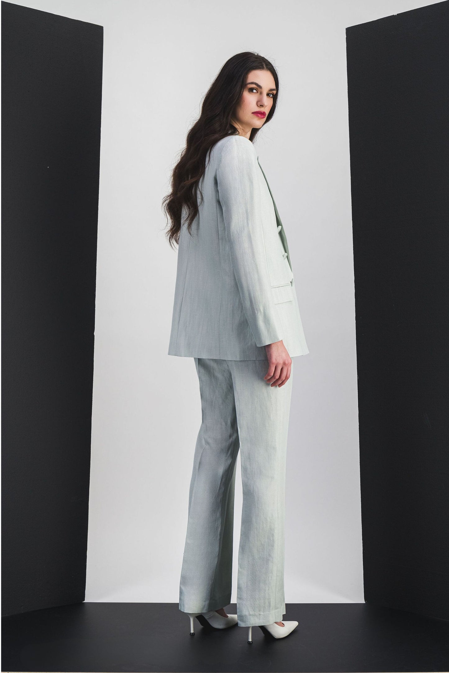 Conçue dans un lin-viscose vert d'eau, cette veste tailleur allie une coupe sophistiquée, des boutons ton sur ton et des poches passepoil pour un style moderne et pratique.