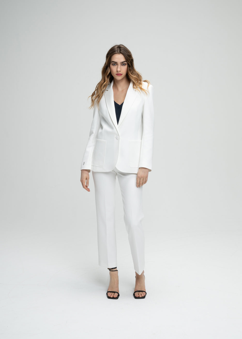 Veste tailleur cintrée blanc avec poches plaquées, col tailleur et détail monogramme manche
