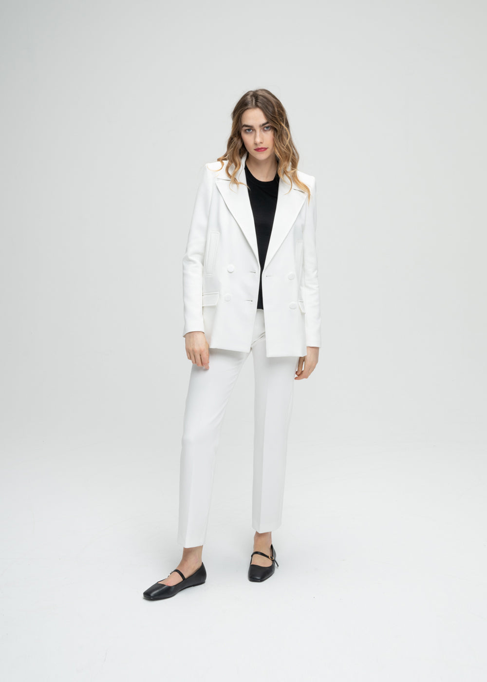 Modèle portant un manteau caban blanc à coupe droite pour une allure subtilement surdimensionnée. Doté d’un double boutonnage croisé, de poches passepoilées et de poches à rabat fonctionnelles. Le logo sur chaque élément ajoute une touche personnalisée et raffinée à ce modèle élégant.