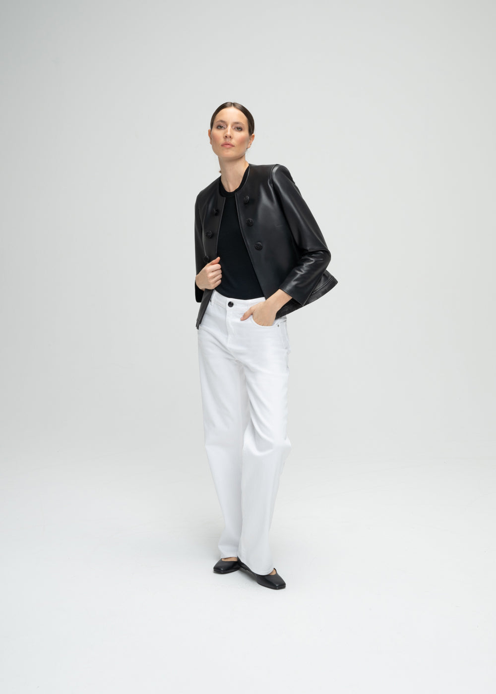 Veste courte en cuir noir avec 6 boutons à l'avant, détails franges dos et bords