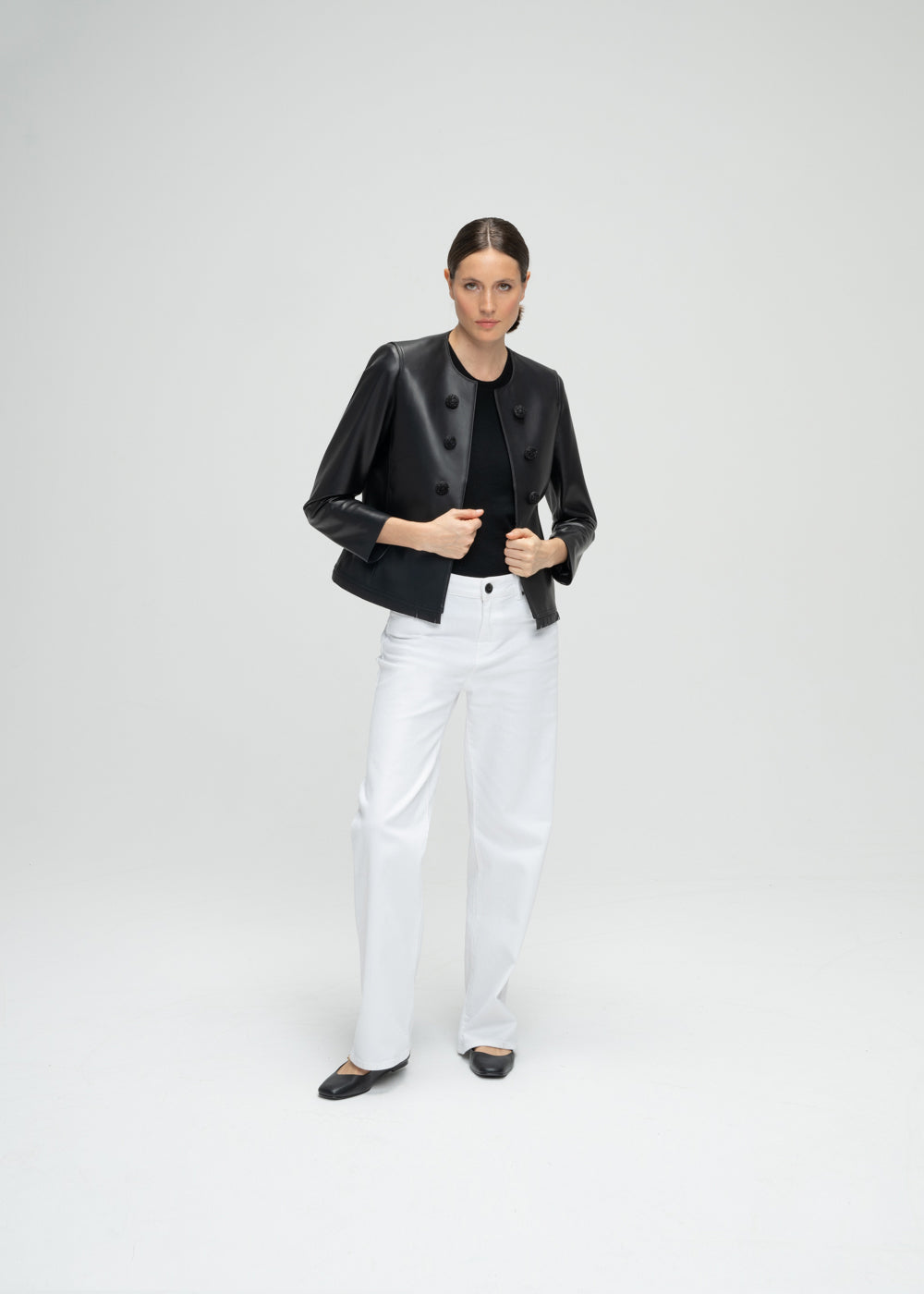 Veste courte en cuir noir avec 6 boutons à l'avant, détails franges dos et bords