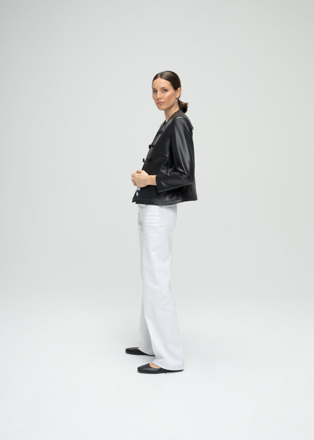 Veste courte en cuir noir avec 6 boutons à l'avant, détails franges dos et bords