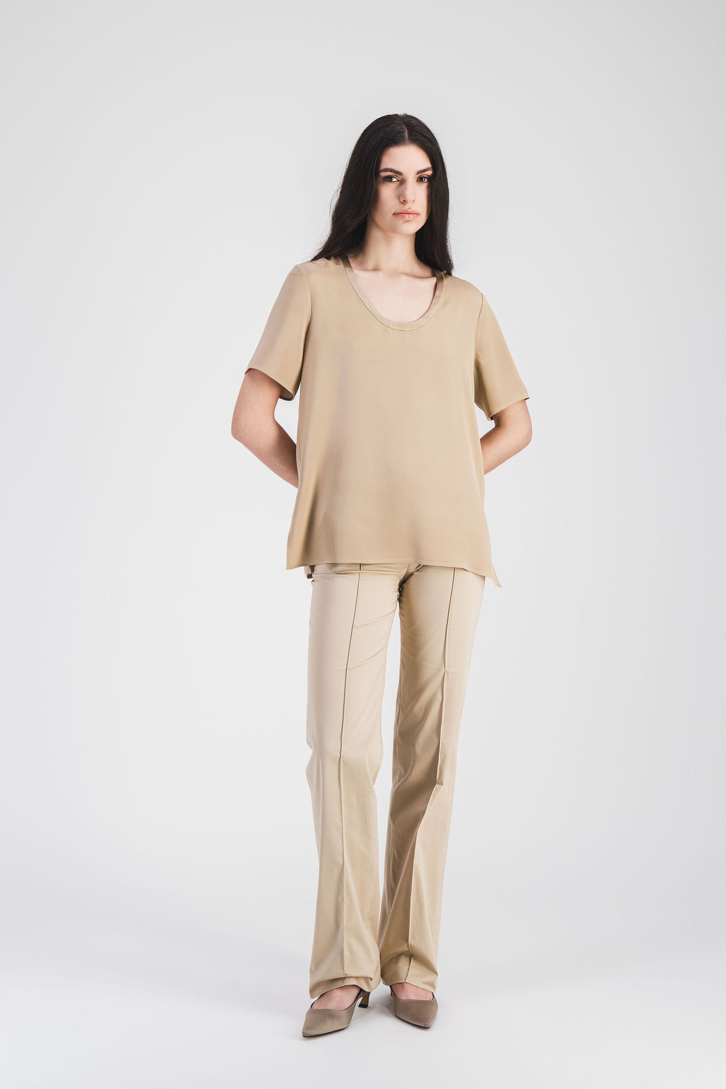Silhouette fluide et chic de la blouse beige en soie.
