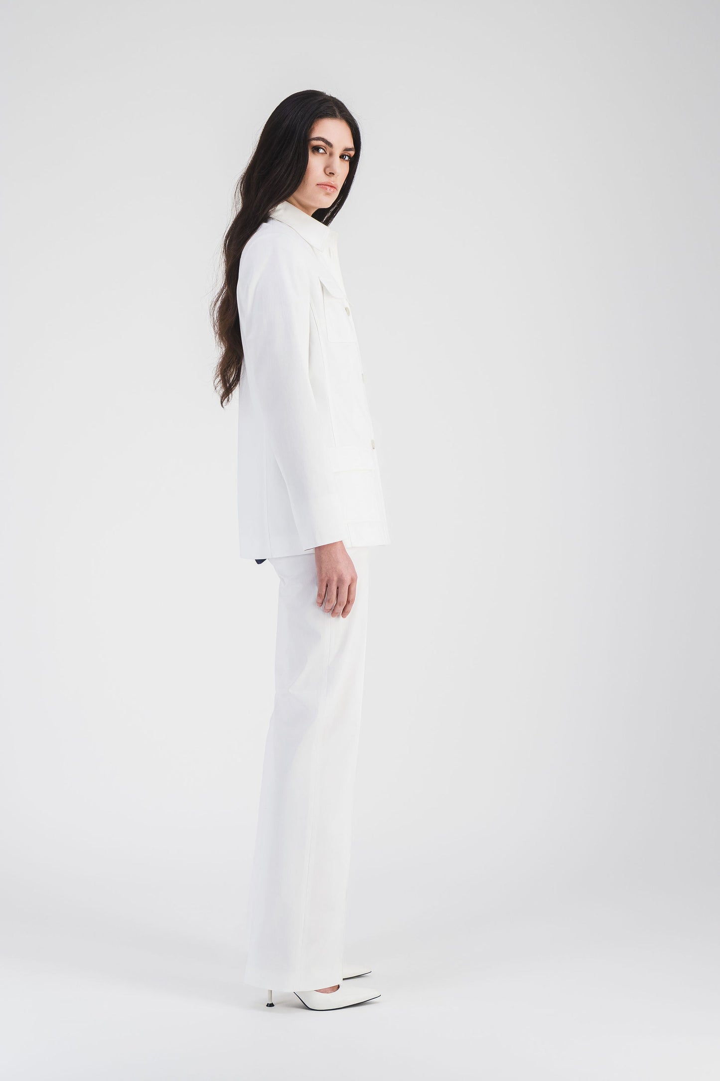 Pantalon en satin de coton blanc optique, coupe fluide et poches italiennes discrètes, allongeant la silhouette.