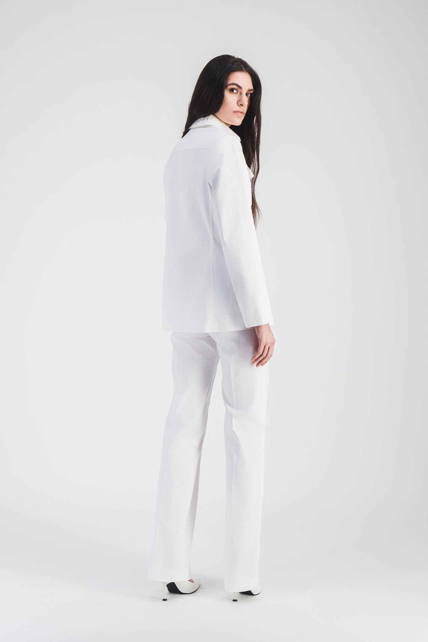 Pantalon évasé blanc en satin de coton, avec coupe fluide et poches italiennes.