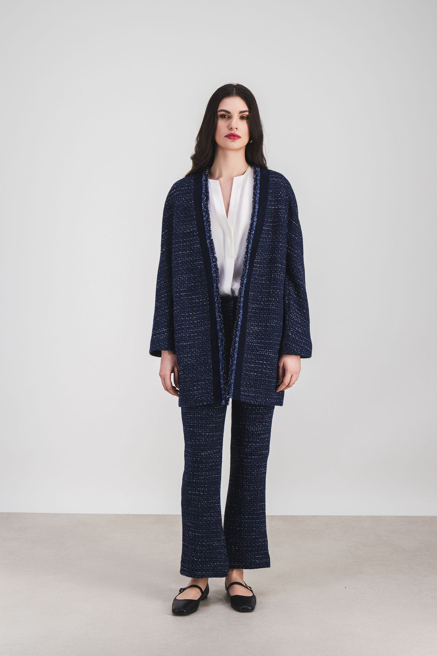 Manteau fluide marine, franges discrètes et finitions soignées.