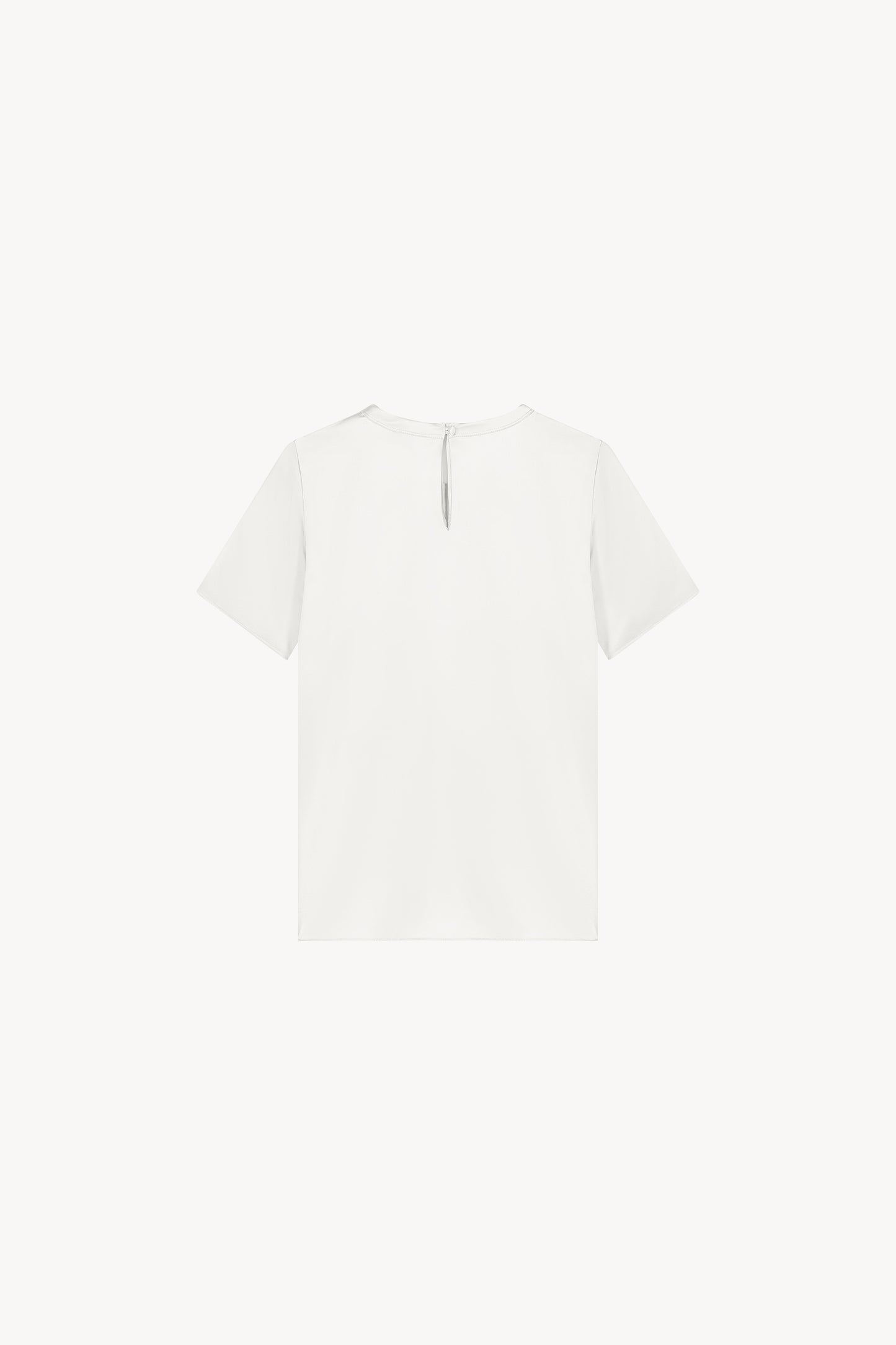 T-shirt en soie blanc, minimaliste et au look soyeux, parfait pour élever votre style sans effort. Il présente un col rond, des manches courtes, une fermeture à bouton dans le dos et une forme goutte avec un bouton recouvert, alliant élégance et simplicité.