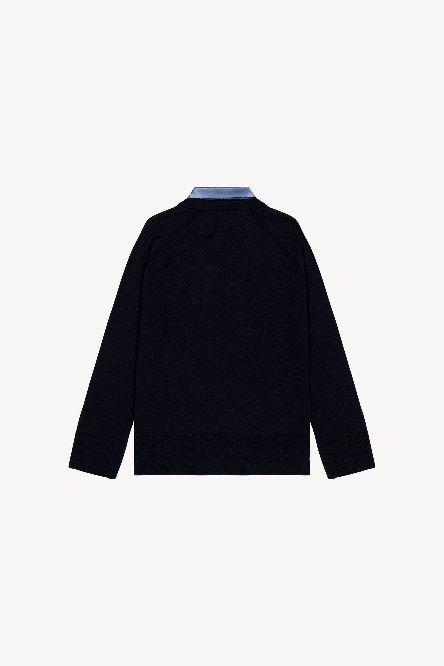 Pull moderne en laine marine, fusionnant maille et satin avec col chemise et finitions satinées sur le bas.