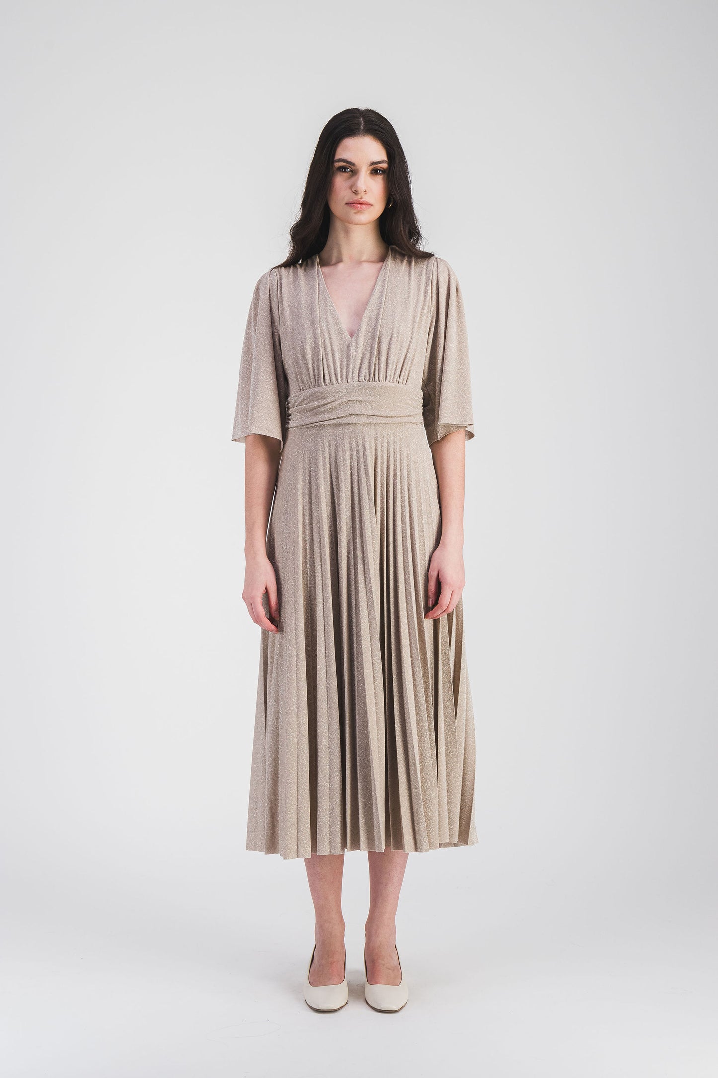 Subtilement cintrée, cette robe longue à manches volantées et col V profond, avec tissu scintillant et plissé soleil, offre une allure élégante.
