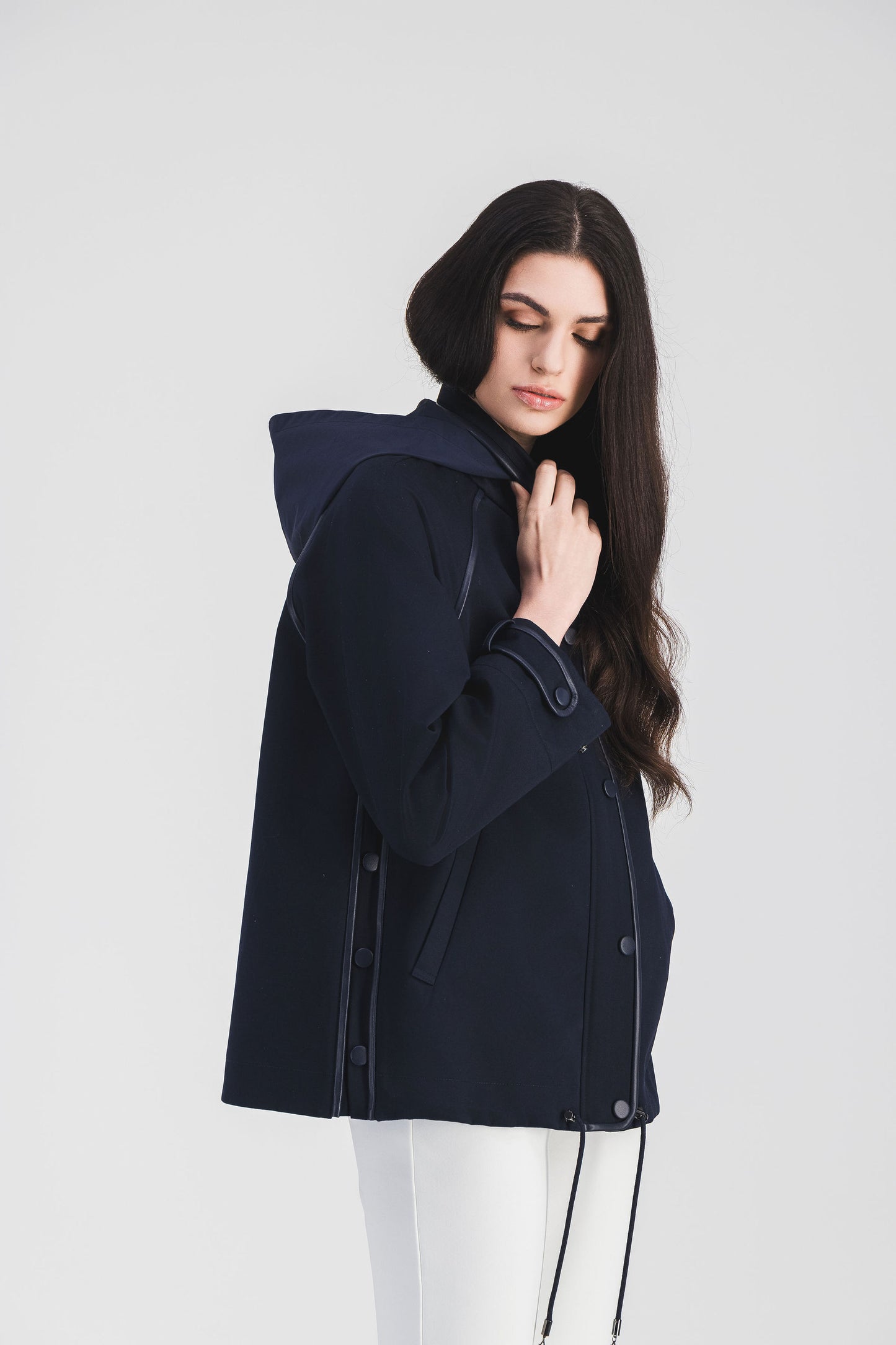 Trench imperméable bleu marine avec finitions contrastées et coupe moderne, idéal pour un style urbain élégant.
