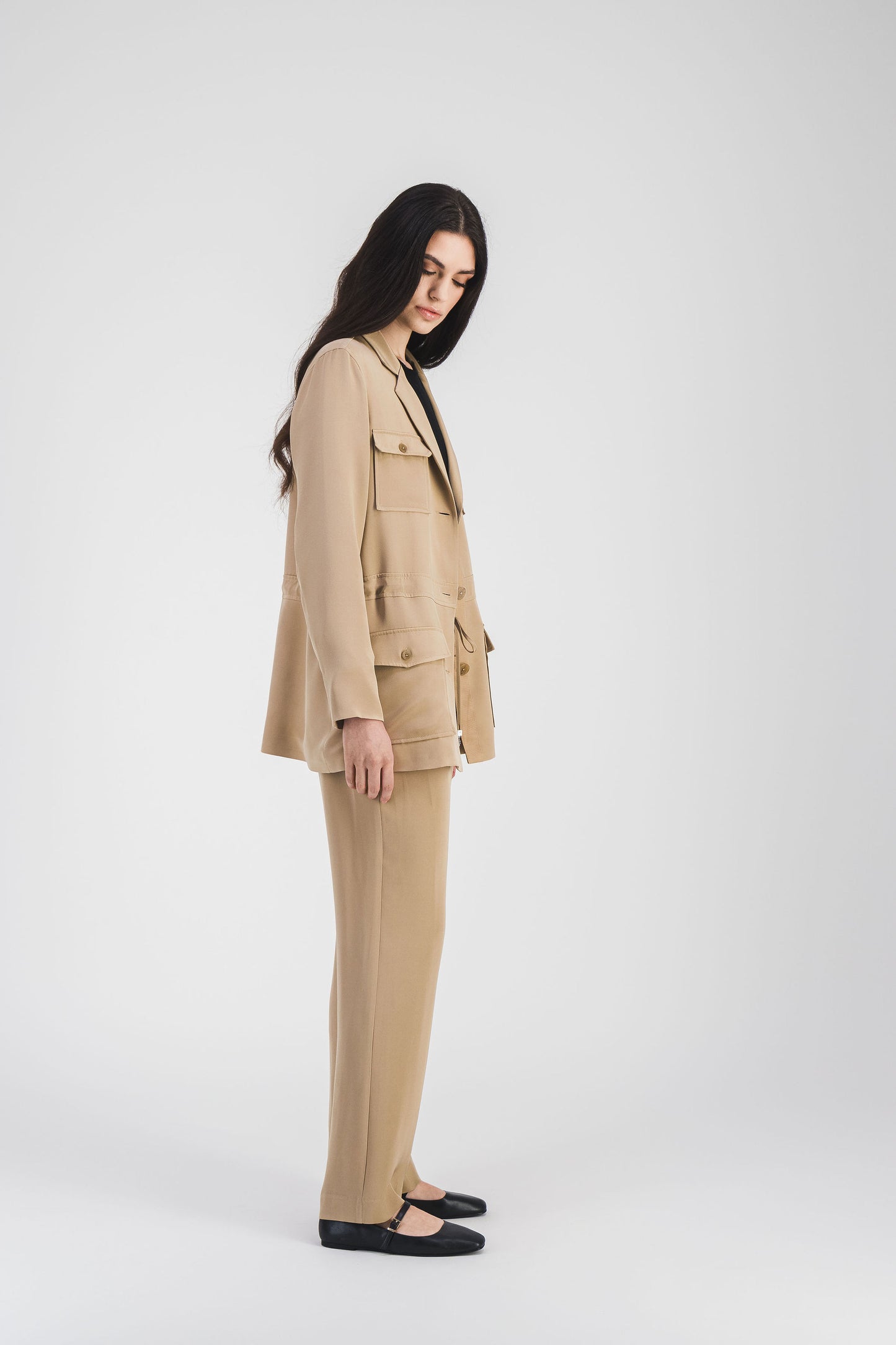 Veste saharienne en soie beige, col tailleur et cordon ajustable avec embouts métalliques gravés pour une silhouette raffinée.