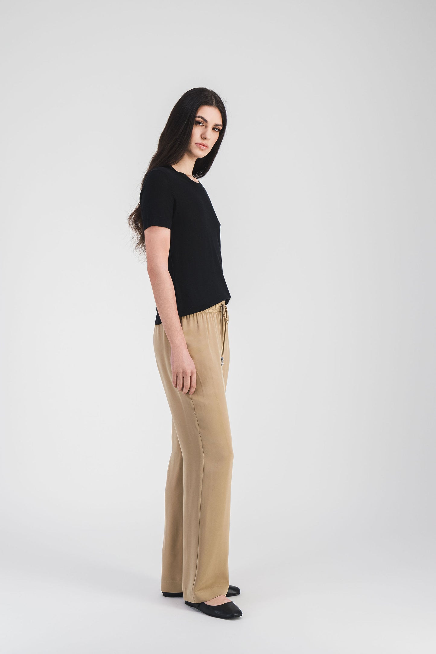 Ce pantalon fluide en soie, coupe droite et taille ajustable, pour une allure chic et décontractée.