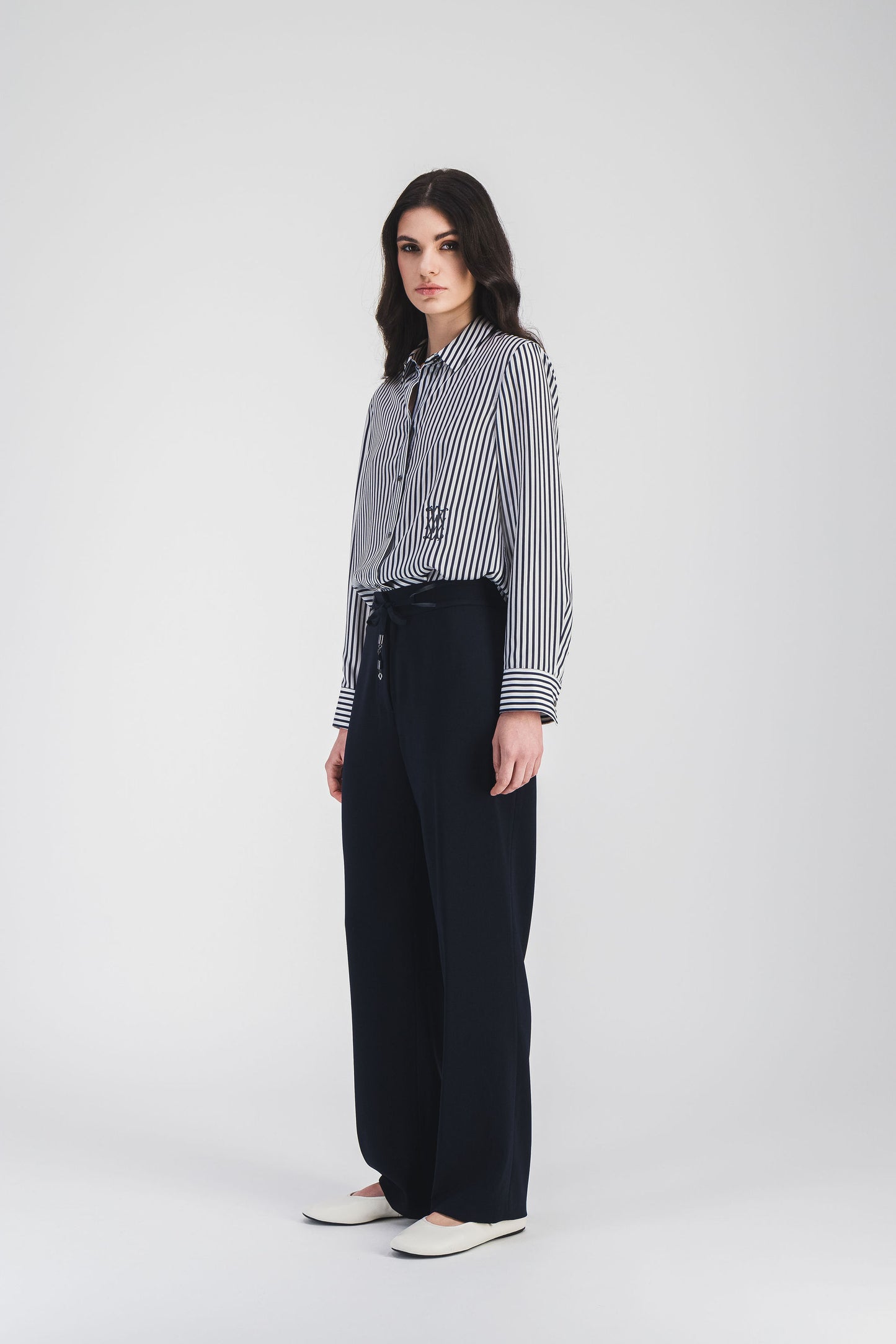 Avec sa taille élastiquée et son cordon en cuir, ce pantalon chic marine est idéal pour un look moderne et raffiné.