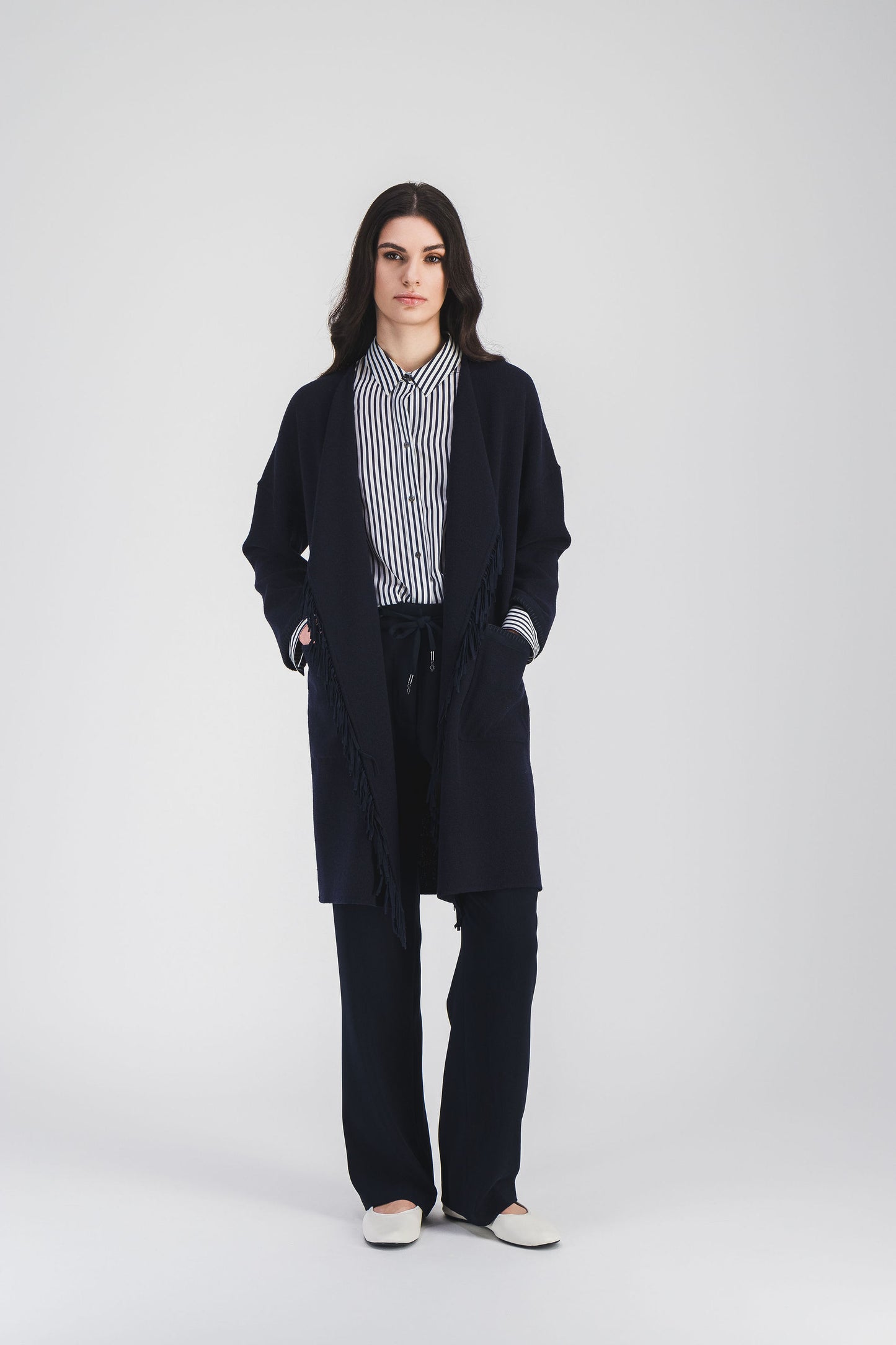 Ce manteau Apostrophe en laine marine , se distingue par ses détails en daims et poches plaquées pour un look sophistiqué.