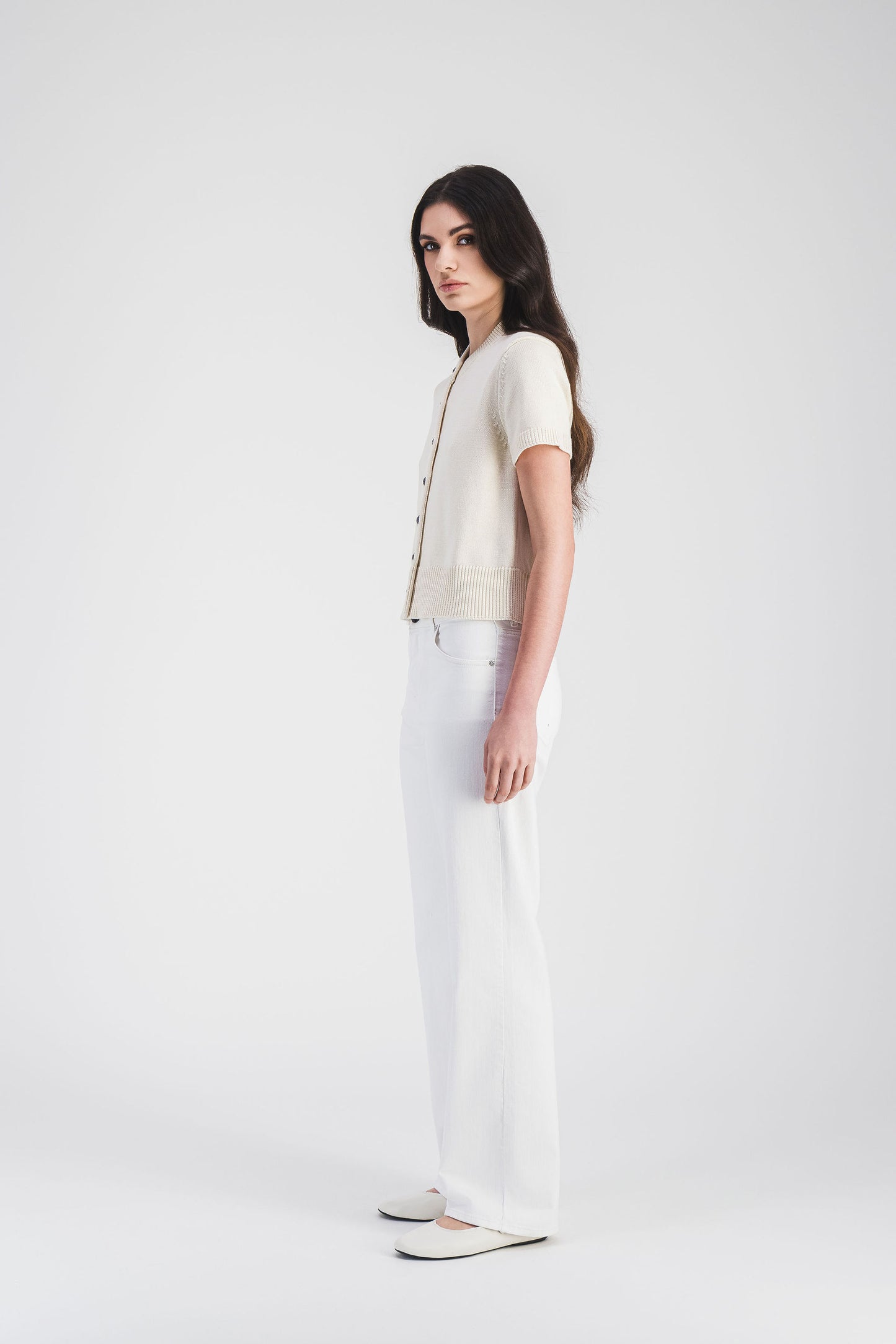 Gilet blanc cassé avec manches courtes, encolure arrondie et boutons métalliques, pour une allure moderne et chic.