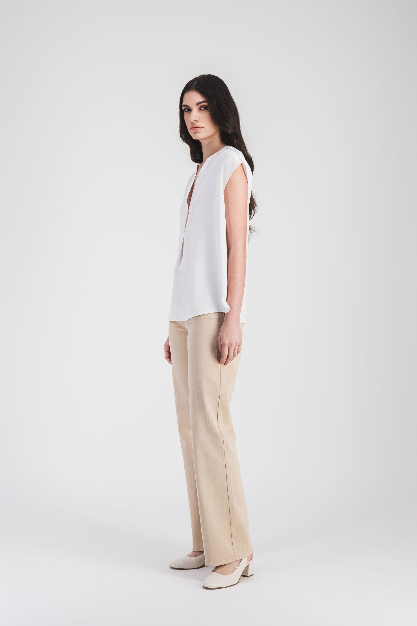Blouse élégante sans manches en soie crêpe de chine, avec un col en V subtil et des finitions soignées.