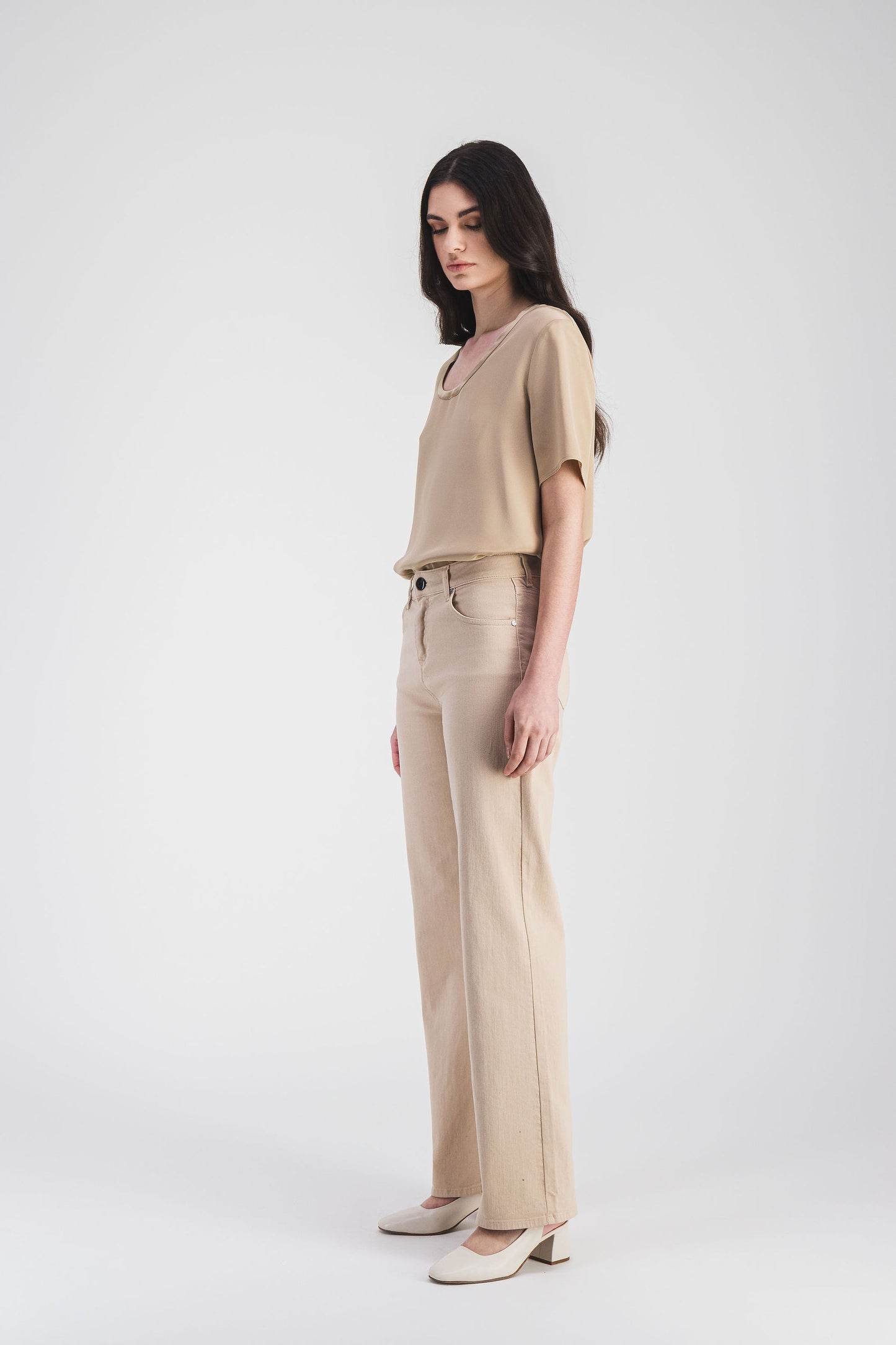 Pantalon slim fit beige en coton extensible, taille mi-haute, poches classiques et fermeture boutonnée discrète.