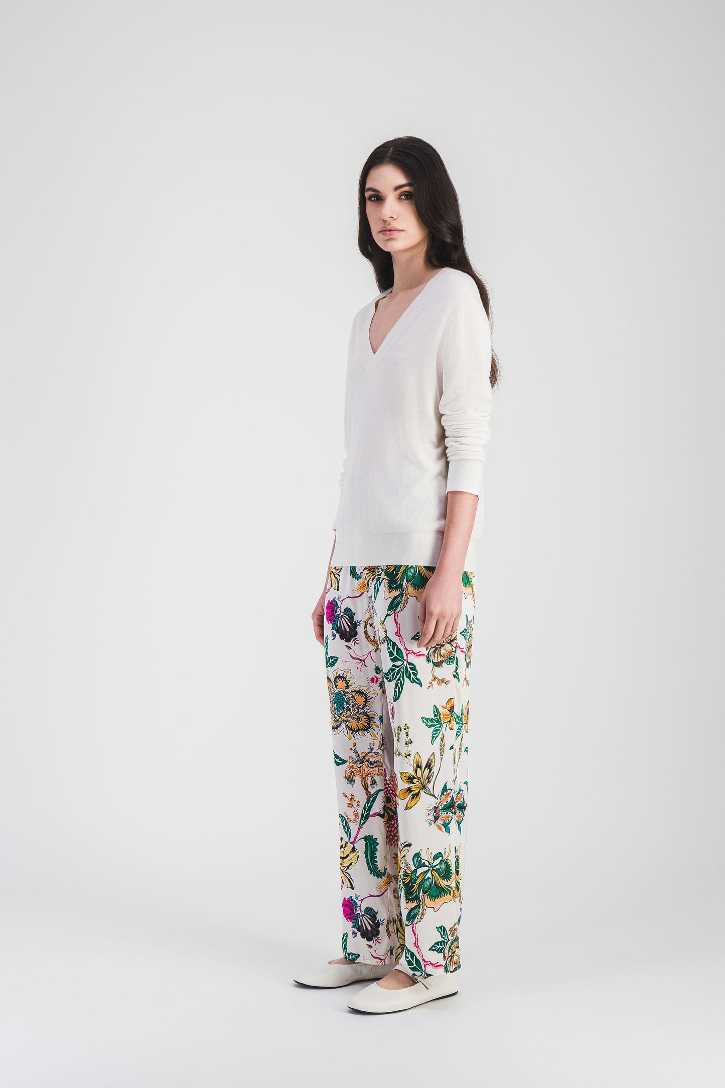 Pull blanc col V en maille légère, ses manches longues et son logo brodé ajoutent une touche moderne à un look élégant.