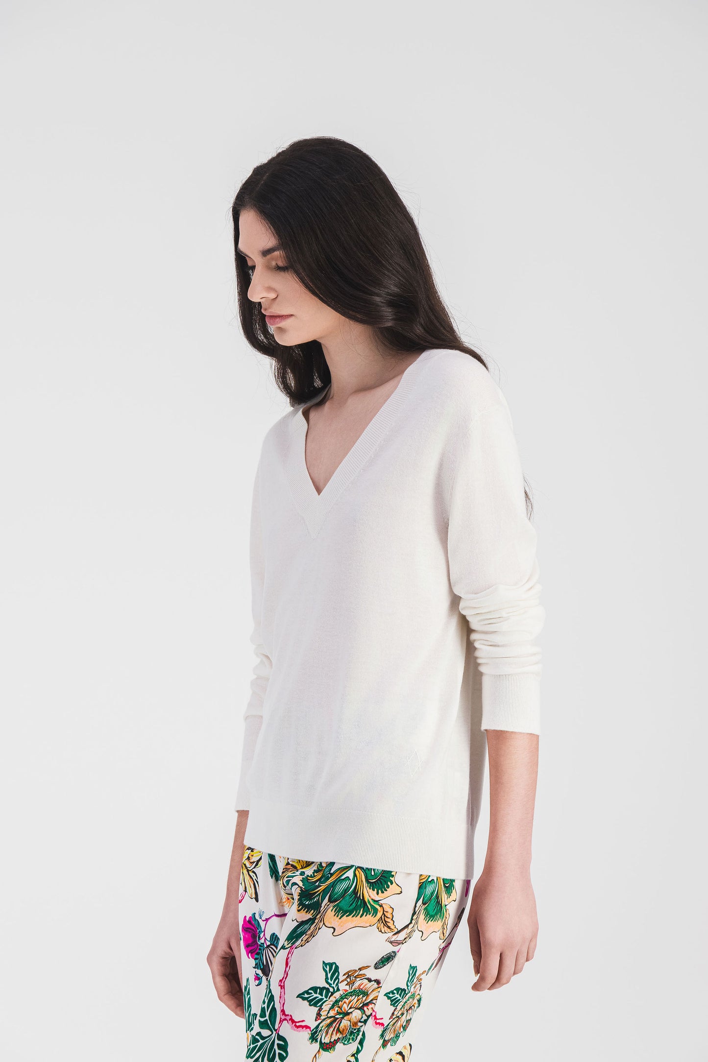 Ce pull blanc à col V, en maille légère, allie confort et élégance avec son logo brodé et ses finitions côtelées.