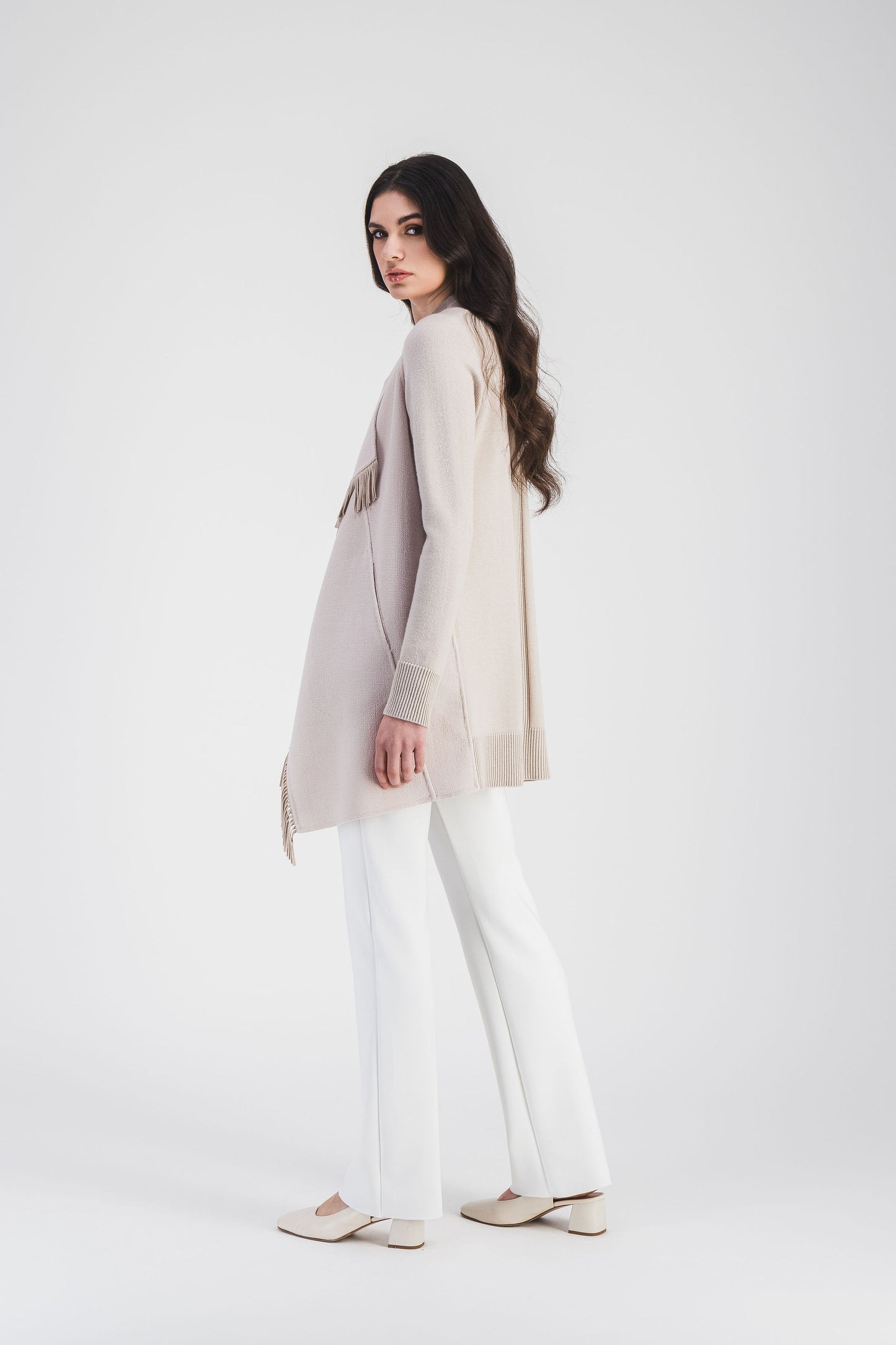 Ce manteau béton bi-matière est orné de franges en daim et d'un col drapé fluide, avec des manches longues côtelées, apporte un style moderne.