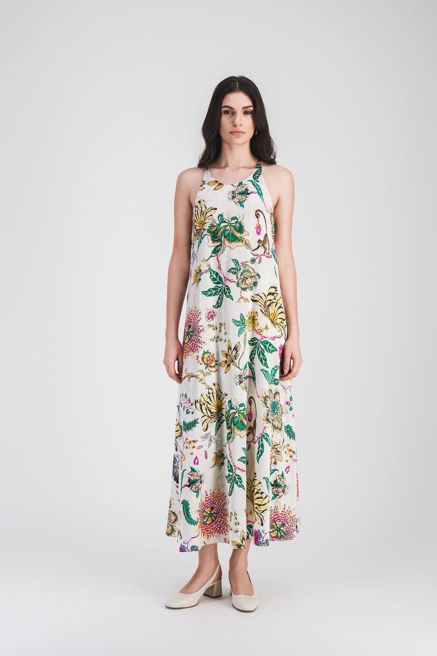 La robe longue à imprimé floral et son bouton au dos créent une allure sophistiquée et moderne, parfaite pour un look raffiné.