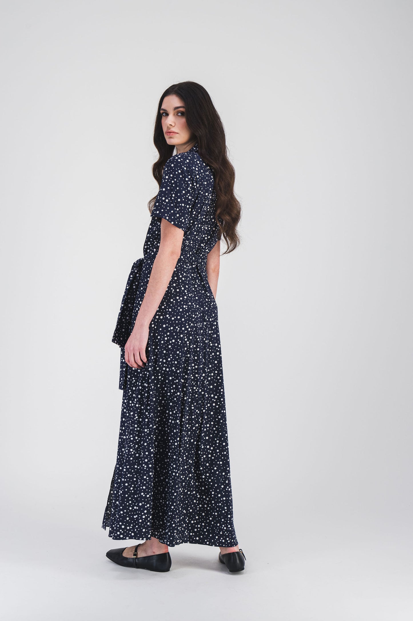 Robe chemise à pois marine avec col chemise et ceinture ajustable, offrant une silhouette élégante et confortable