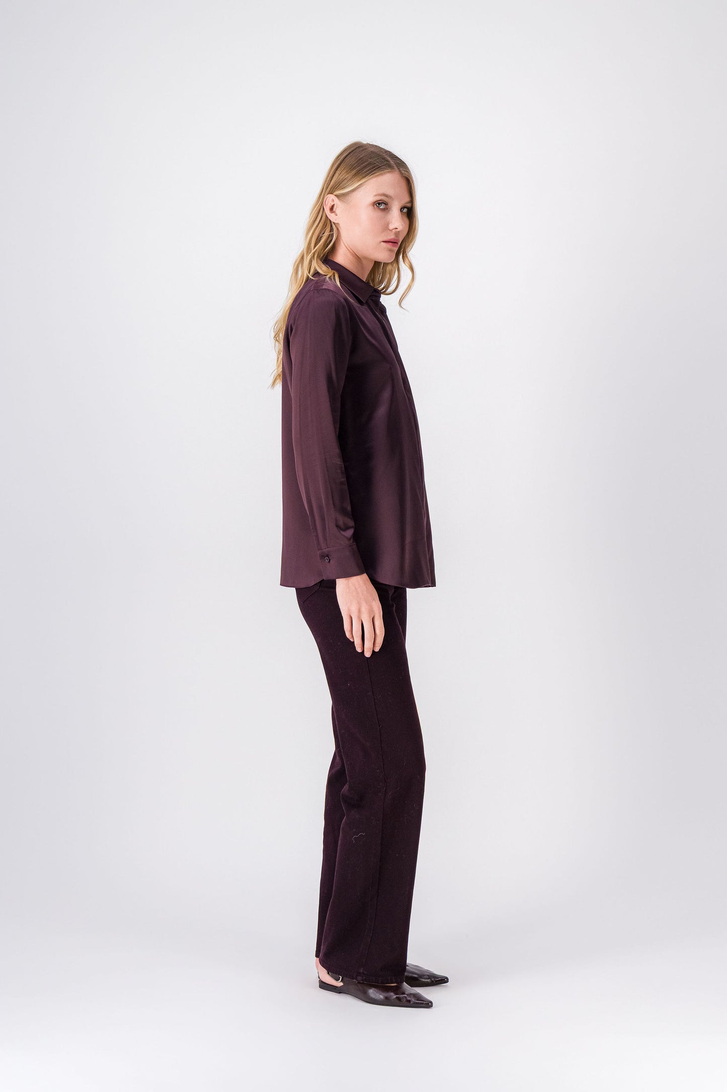 Chemise élégante en soie grenat, col classique, lignes épurées et fentes latérales discrètes pour une fluidité subtile.