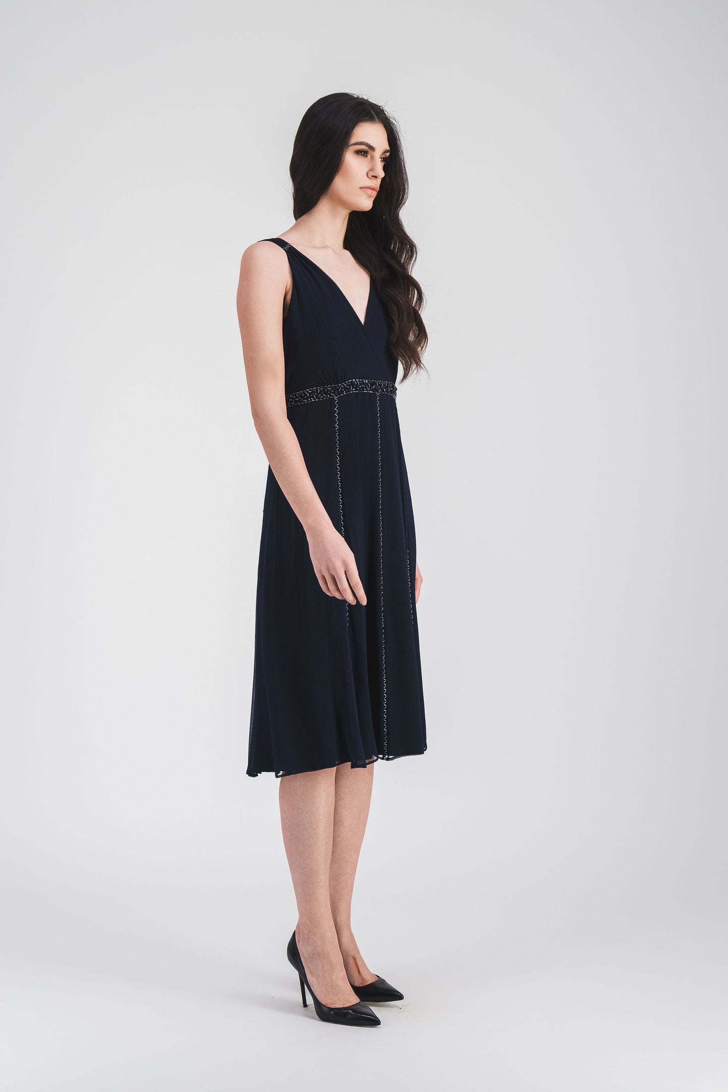 Cette robe courte marine à taille empire et décolleté en V, avec broderie ton sur ton, sublime votre silhouette avec élégance.