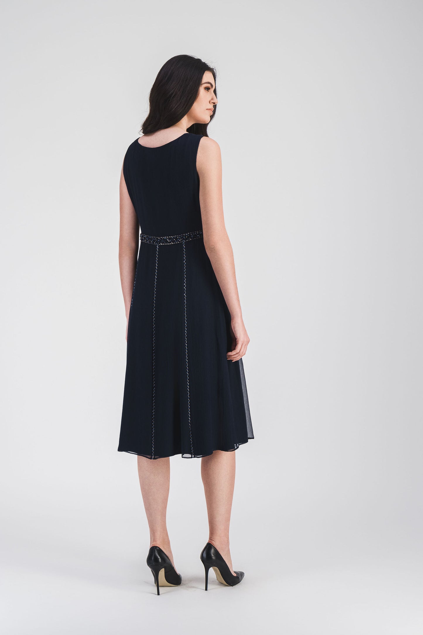 Robe courte marine à taille empire et décolleté en V, broderie ton sur ton pour une silhouette élégante et fluide.