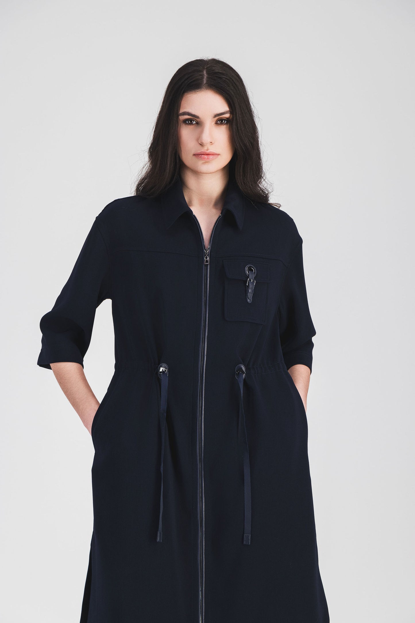 Robe surchemise marine avec fermeture zippée discrète, poche plaquée et cordon ajustable.