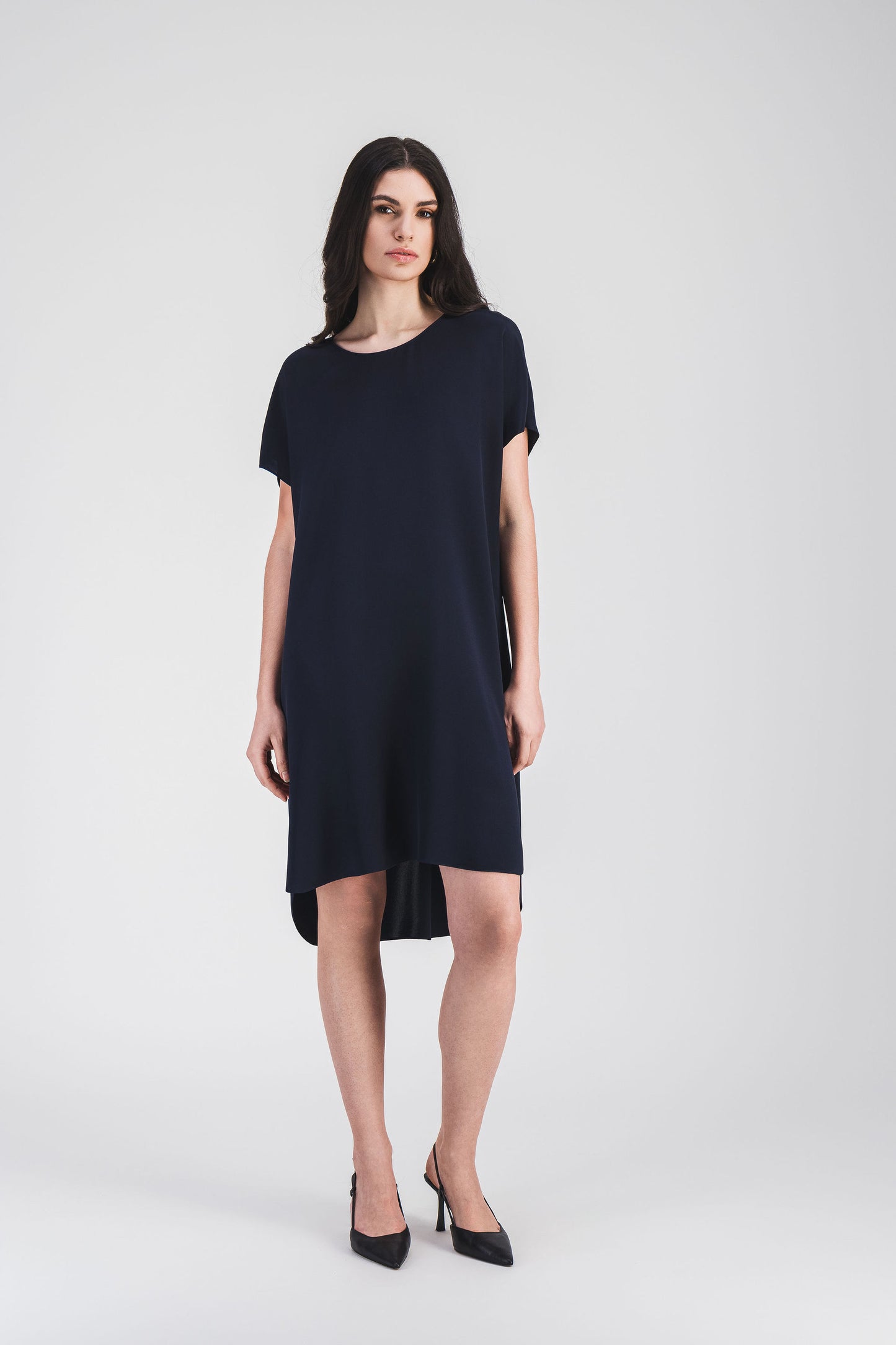 Une robe droite élégante en soie bleu marine, col rond et boutons invisibles pour une silhouette raffinée.