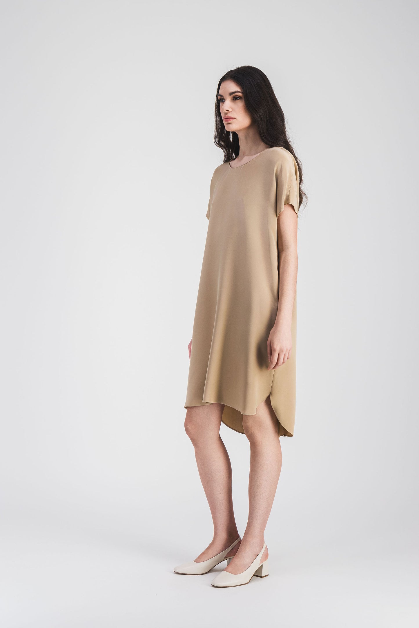 Robe en soie avec fentes latérales et boutons invisibles au dos, une pièce chic pour une allure raffinée.