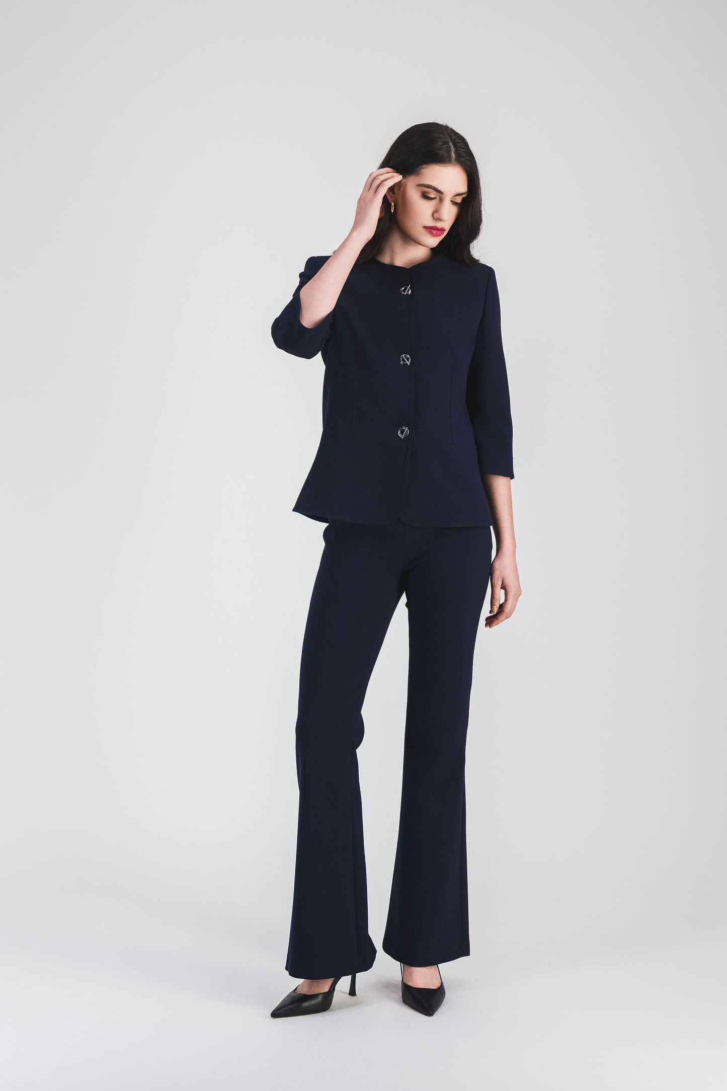 Élégante et contemporaine, cette veste bleu marine à manches 3/4 et boutons œillet métallisés.