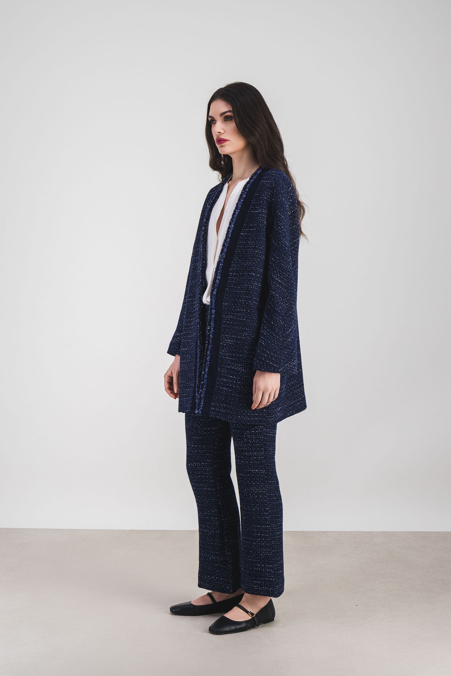 Élégance moderne : manteau tweed marine aux détails en daim et bordures frangées.
