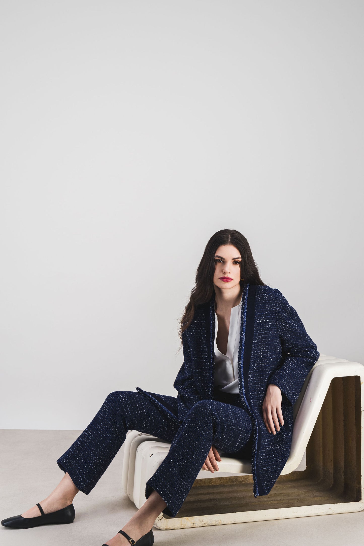 Tweed marine fluide et détails en daim délicat, un manteau raffiné.